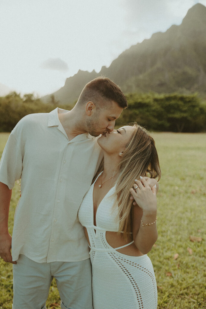 a couple posing in an open field in Oahu for their engagement photos
