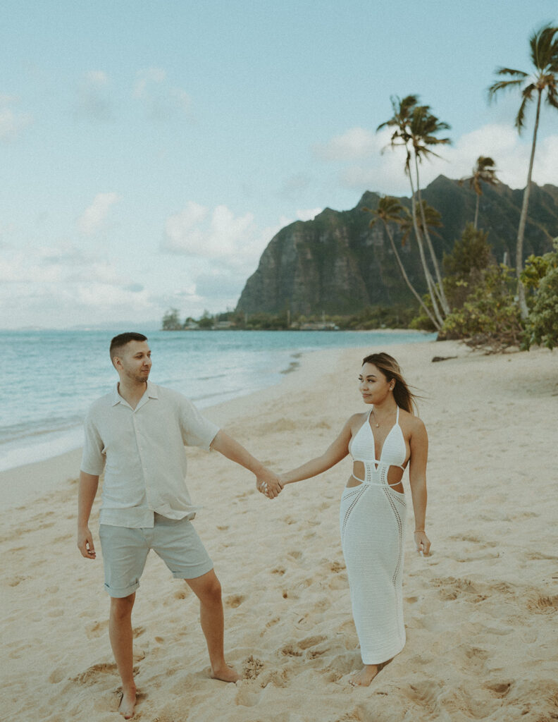 a couple posing for their engagement photos in oahu at kualoa ranch
