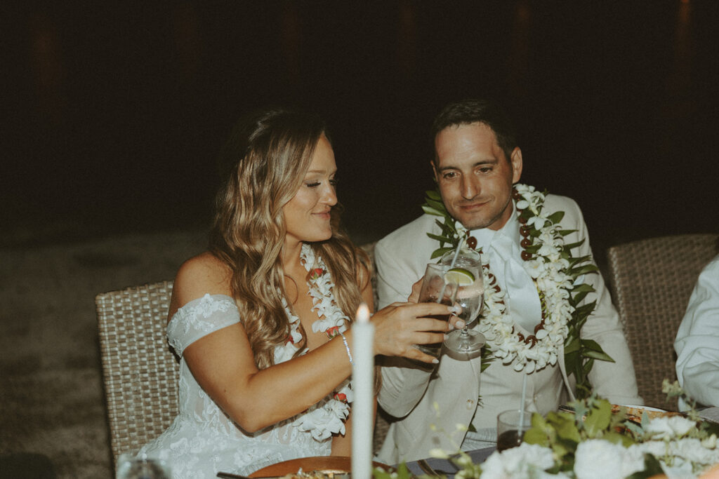 bride and groom in hawaii for their destination wedding having a picnic
