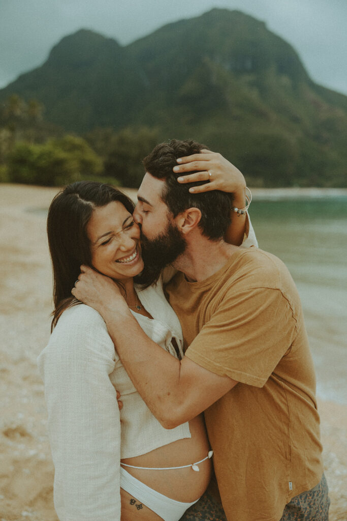 boho maternity session of a couple posing on a beach in kauai for their maternity photoshoot

