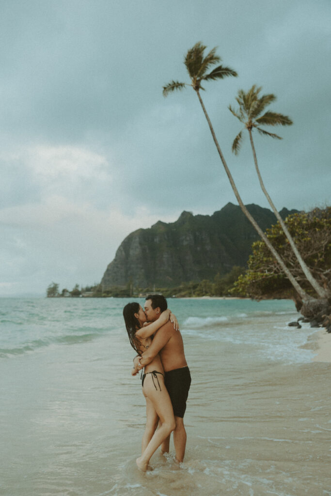 couple taking their honeymoon photoshoot on the beach in hawaii
