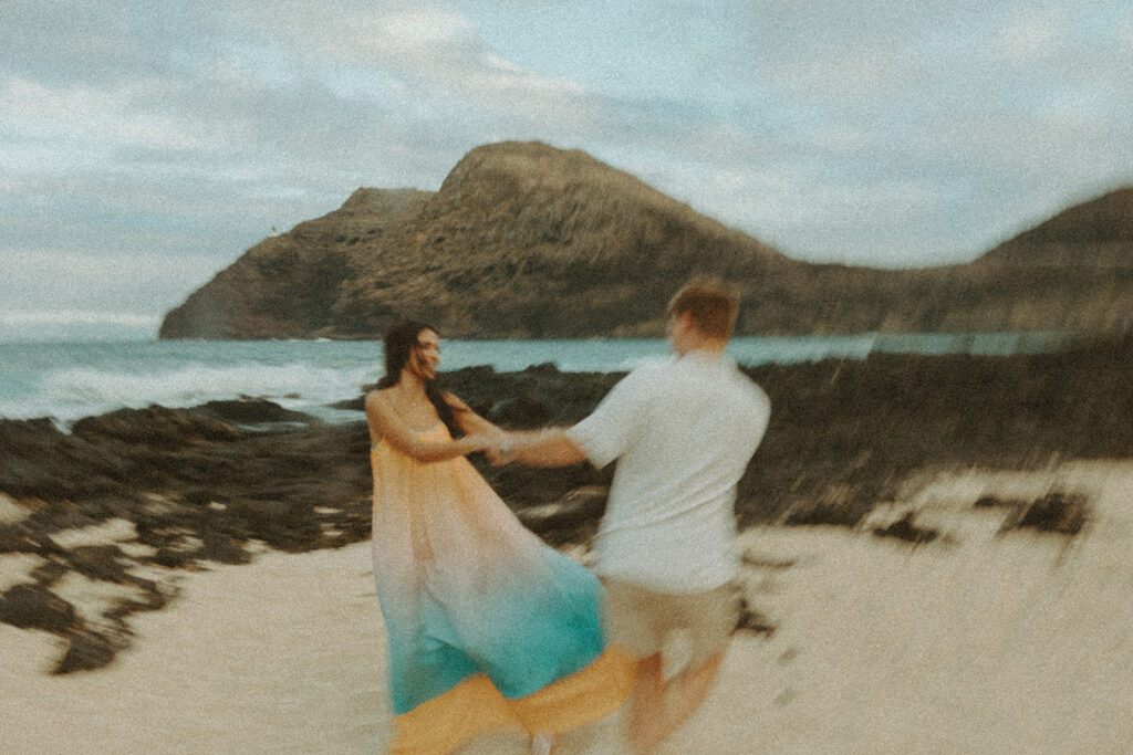 couple posing on the beach for a honeymoon photoshoot
