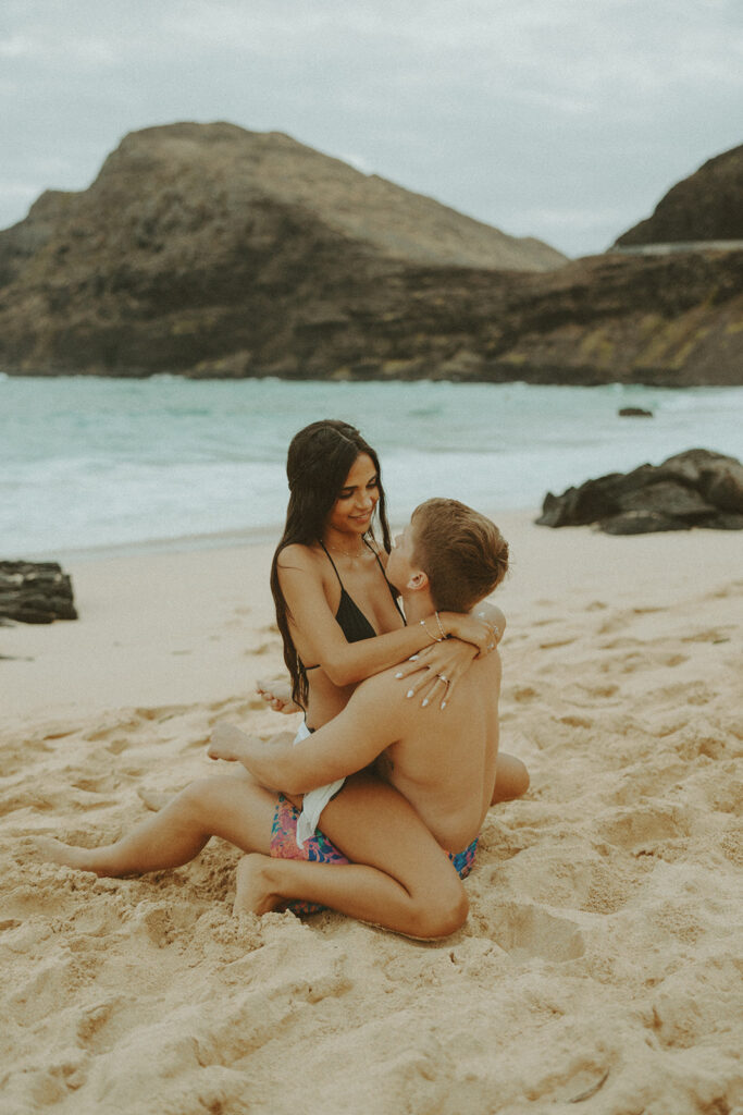 couple posing on the beach for a honeymoon photoshoot