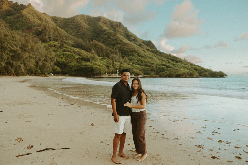 A couple posing on the beaches of hawaii for a honeymoon photoshoot
