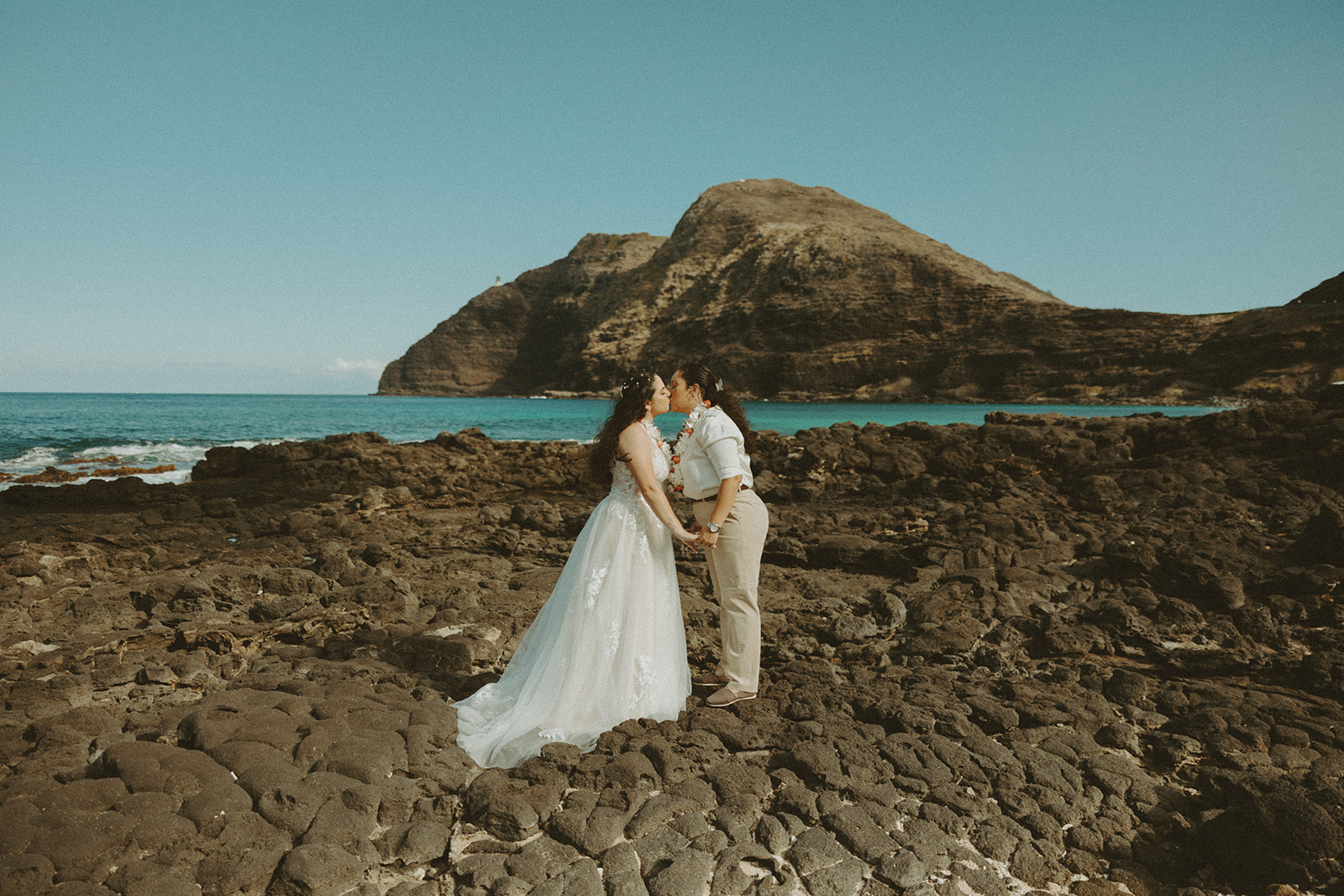 Couple posing on the beach in oahu for their wedding elopement