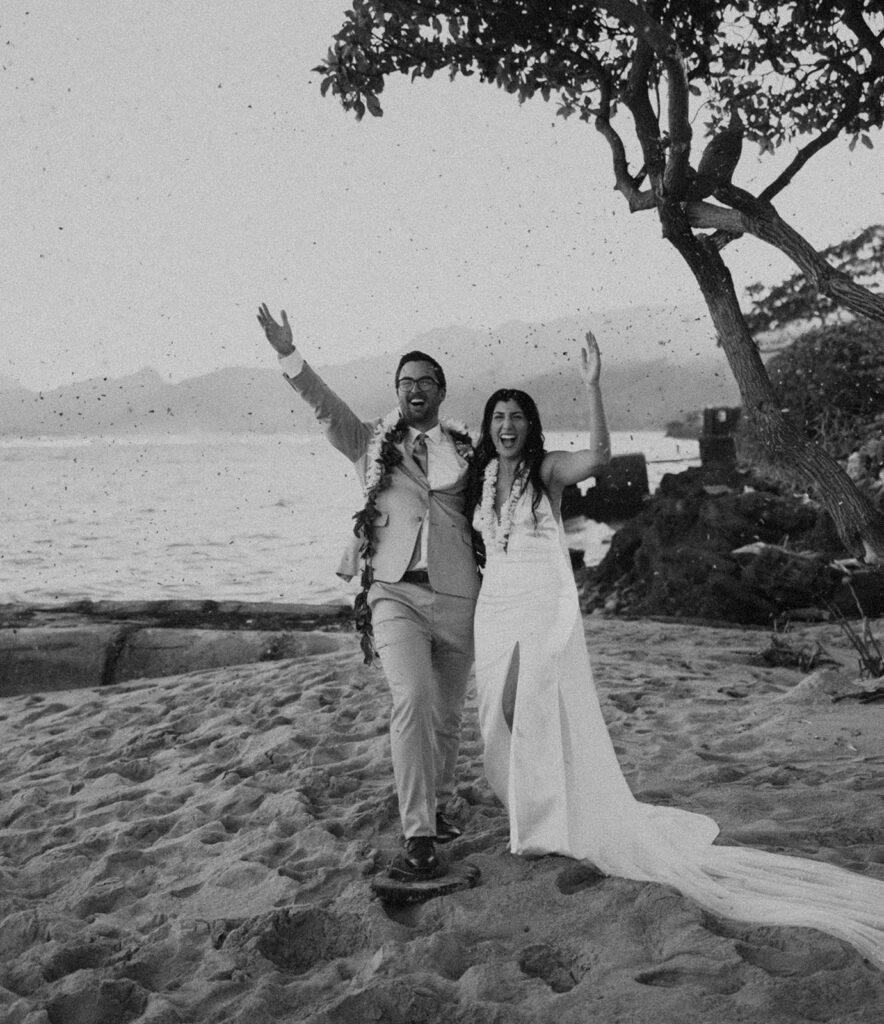 bride and groom posing for wedding portraits on the beach
