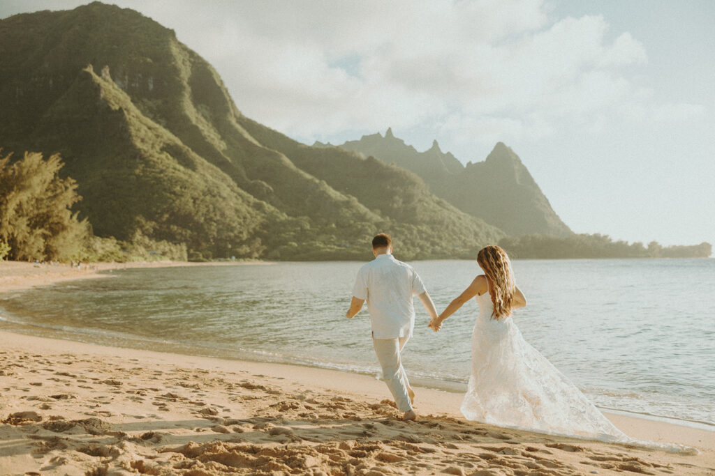 bride and groom posing on the beach for their wedding photos
