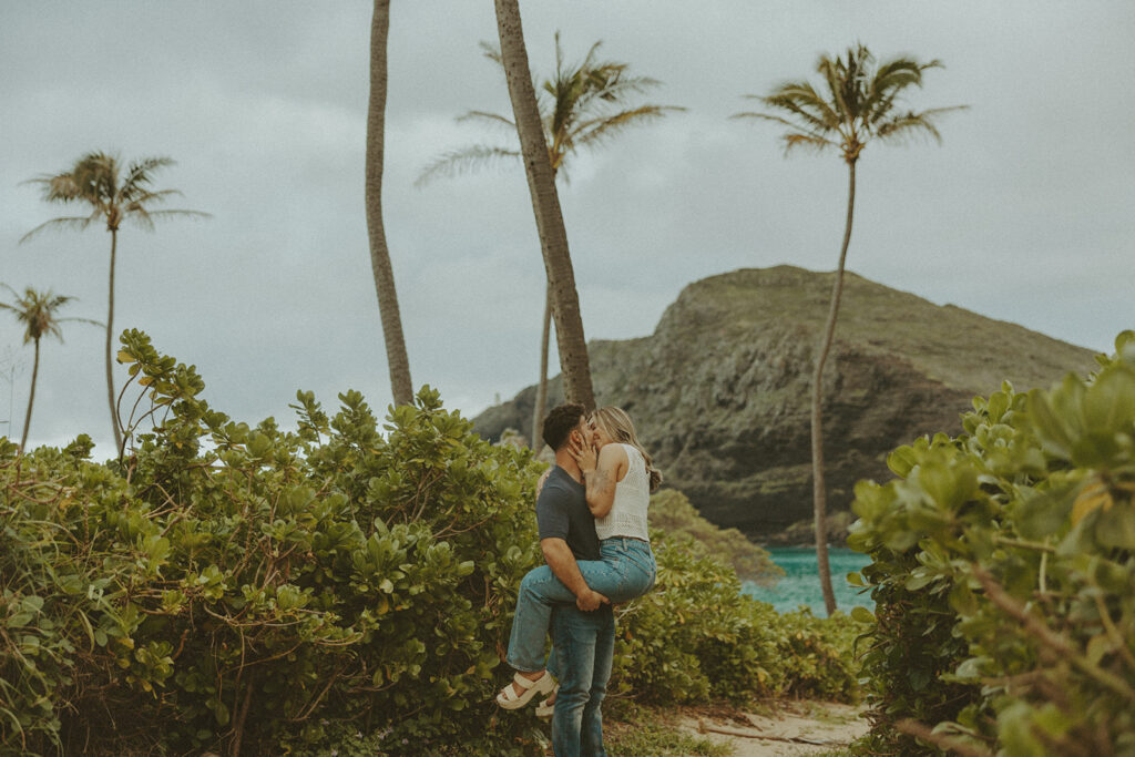 a couple taking engagement photos on a beach
