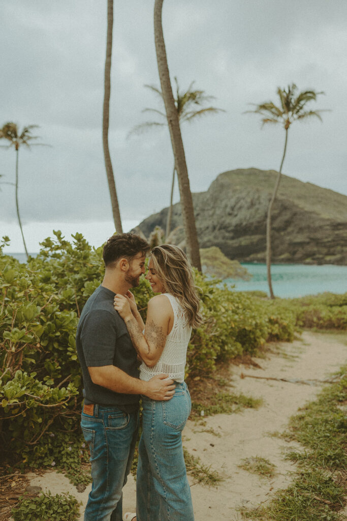 a couple taking engagement photos on a beach
