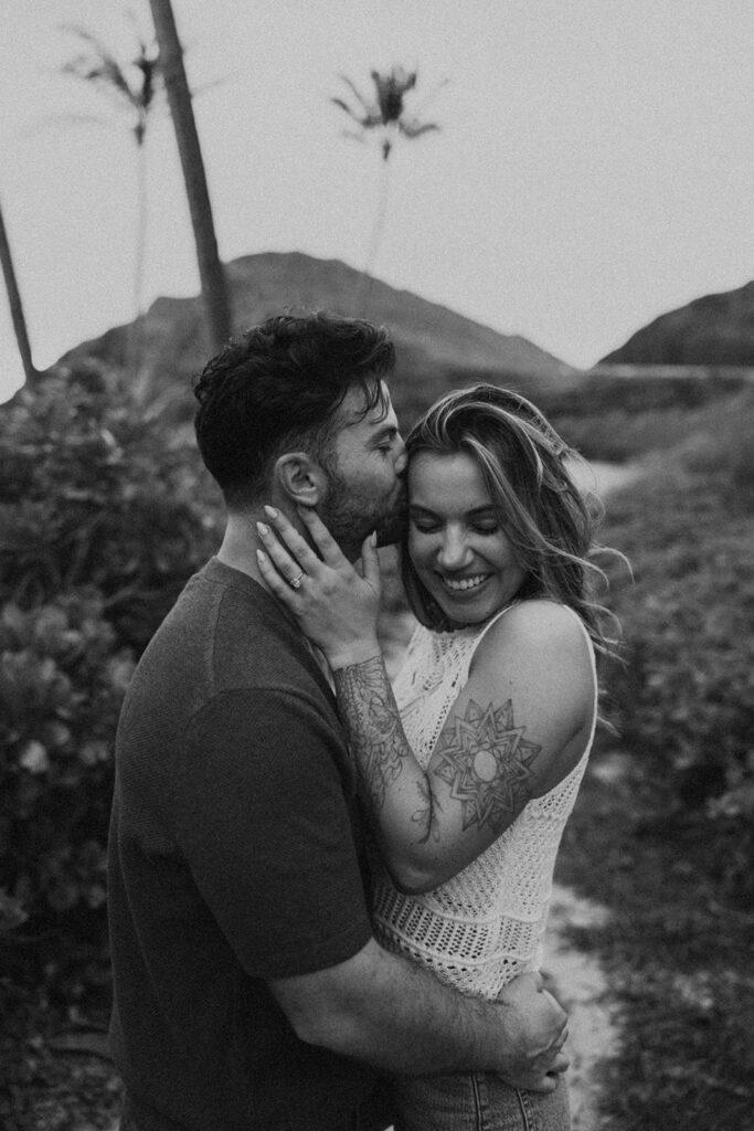 a couple taking engagement photos on a beach
