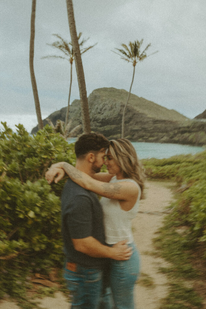 a couple taking engagement photos on a beach
