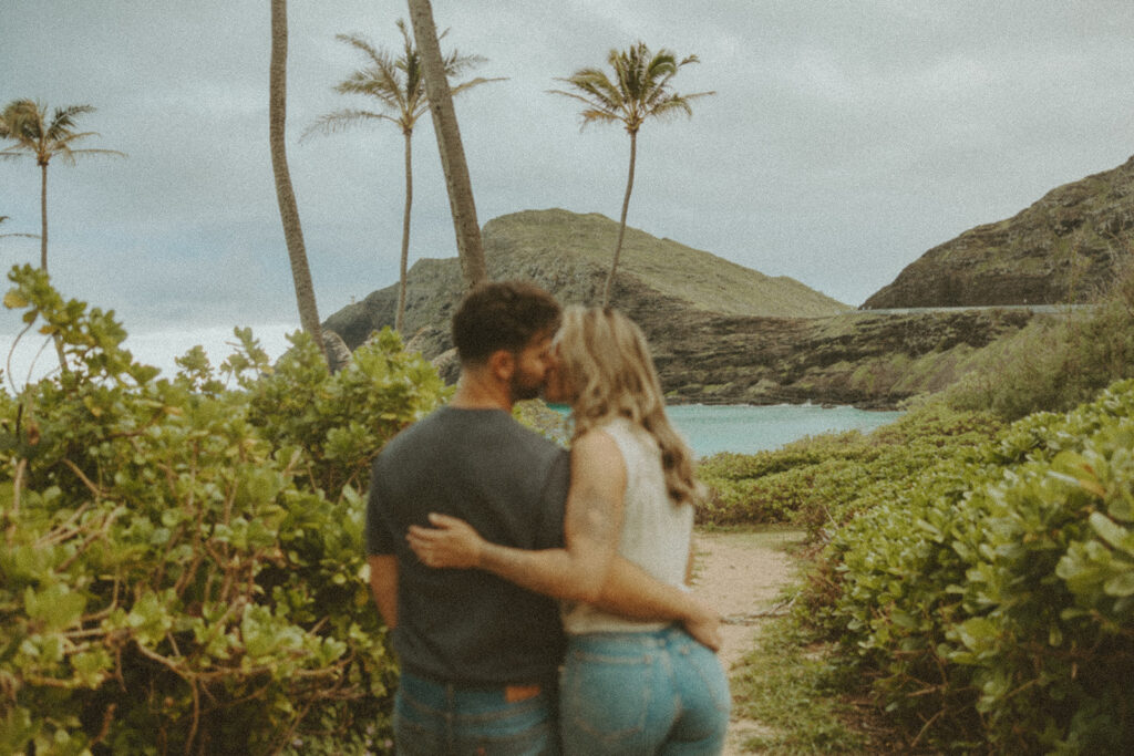 a couple taking engagement photos on a beach
