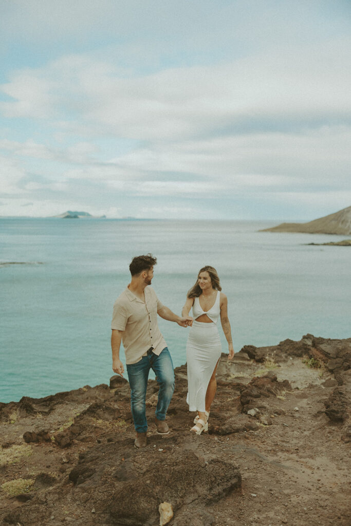 a couple taking engagement photos on a beach
