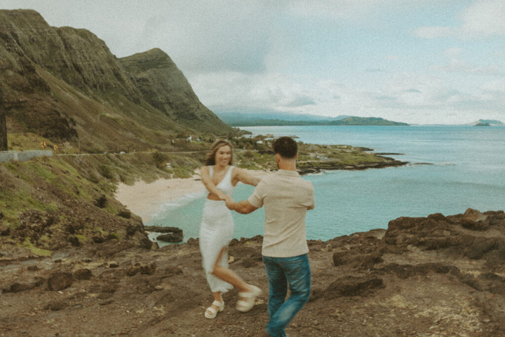 a couple taking engagement photos on a beach
