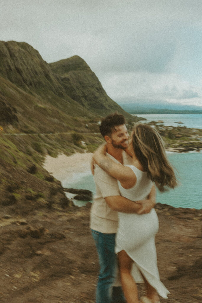 a couple taking engagement photos on a beach
