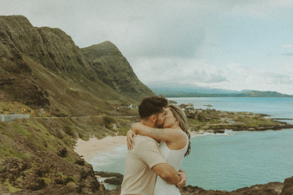 a couple taking engagement photos on a beach
