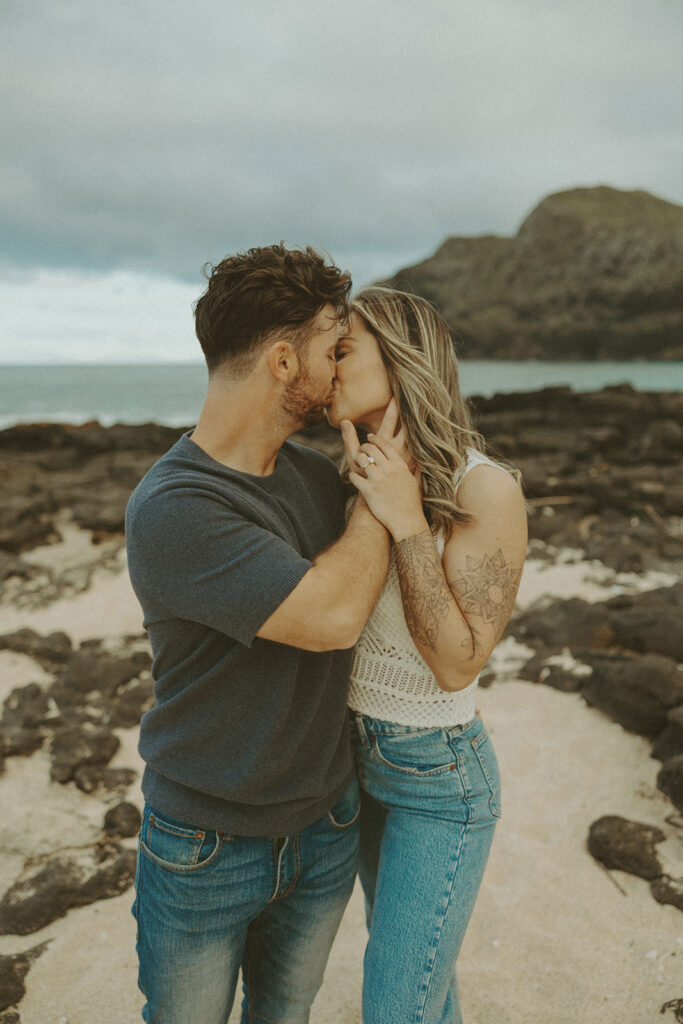 a couple taking engagement photos on a beach
