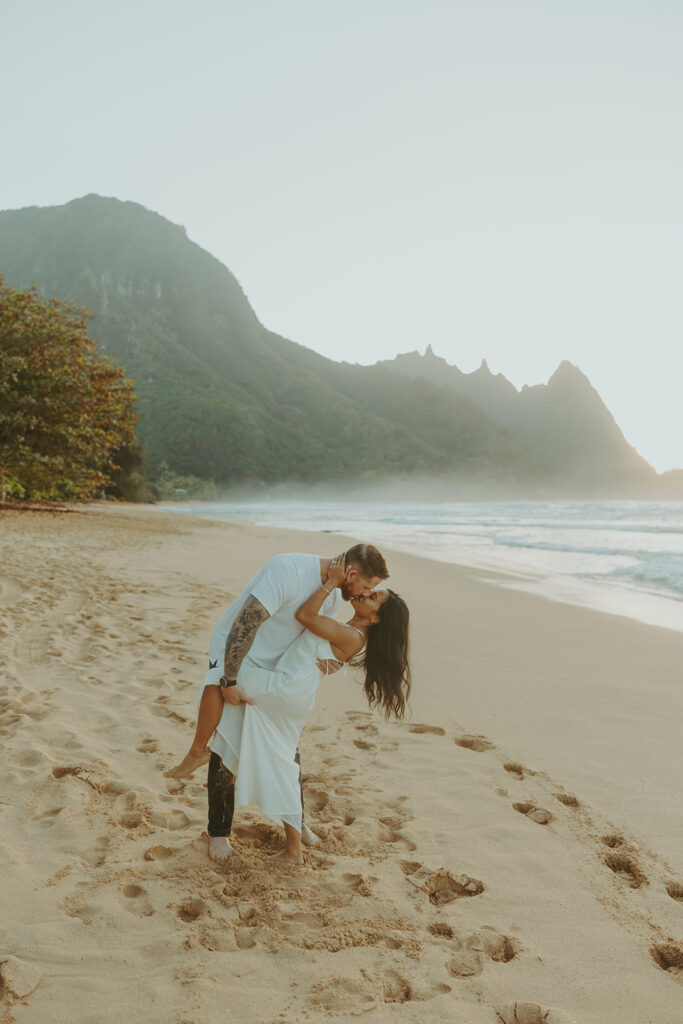 Candid moment of couple walking along the shoreline at Tunnels Beach
