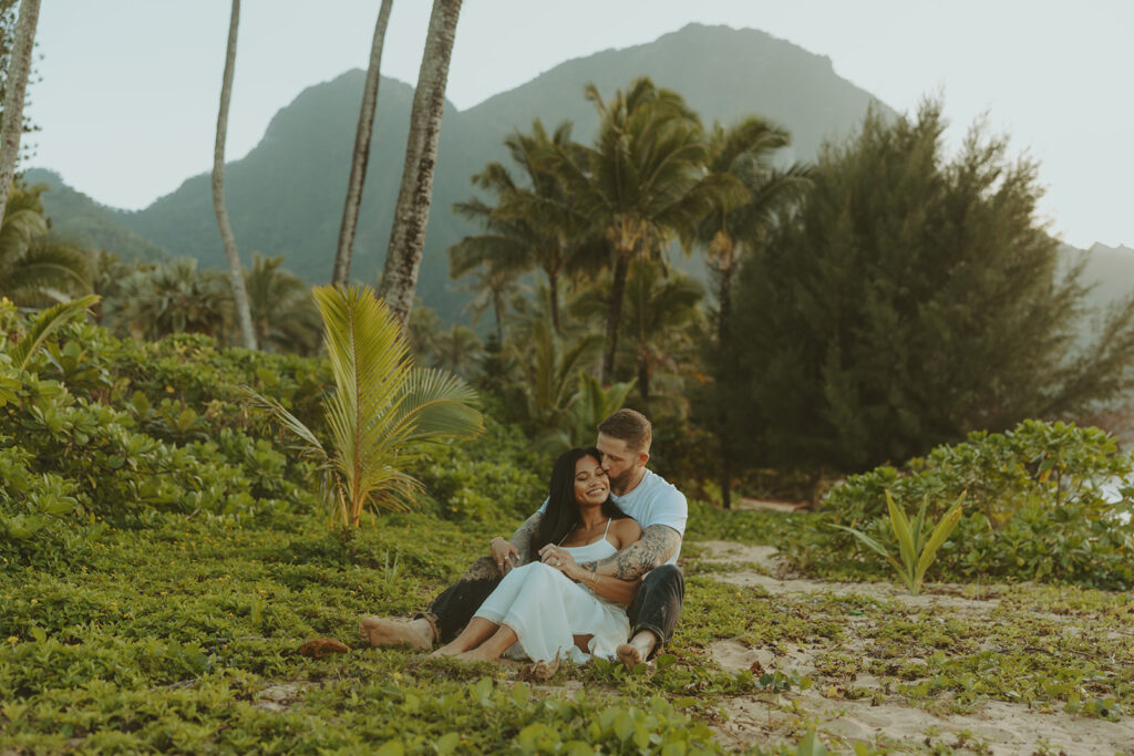 Couple standing together on Tunnels Beach at sunset
