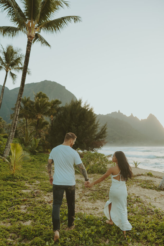 Couple standing together on Tunnels Beach at sunset
