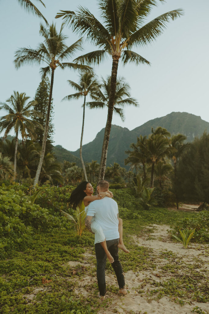Couple standing together on Tunnels Beach at sunset
