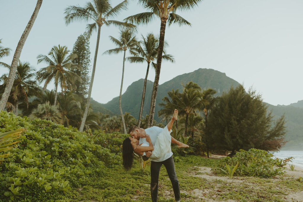 Couple standing together on Tunnels Beach at sunset
