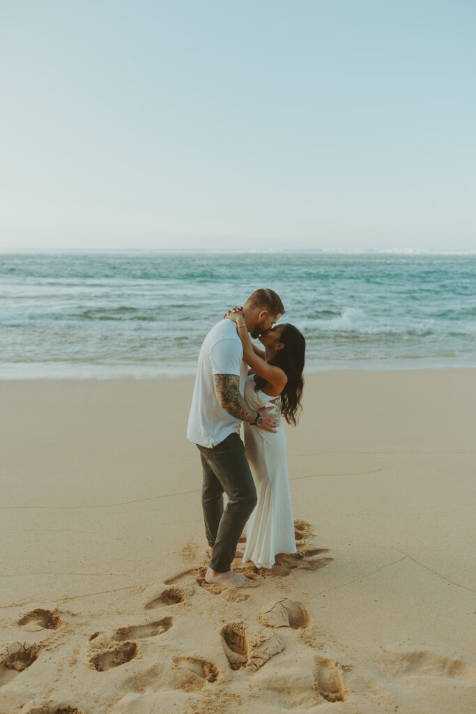 Candid moment of couple walking along the shoreline at Tunnels Beach
