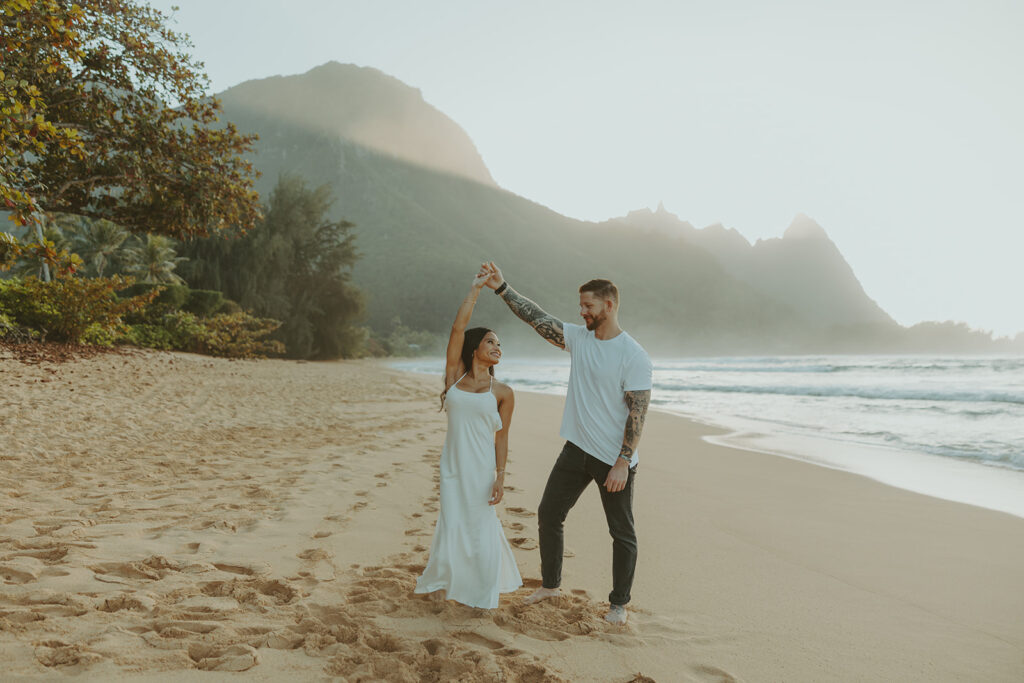 Couple standing together on Tunnels Beach at sunset
