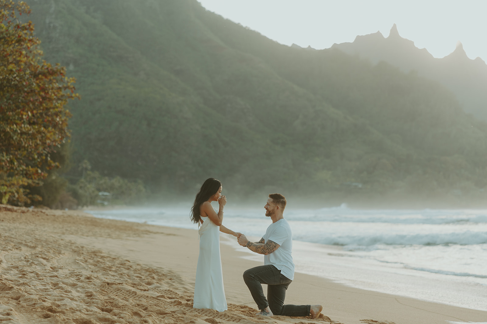 Couple standing together on Tunnels Beach at sunset