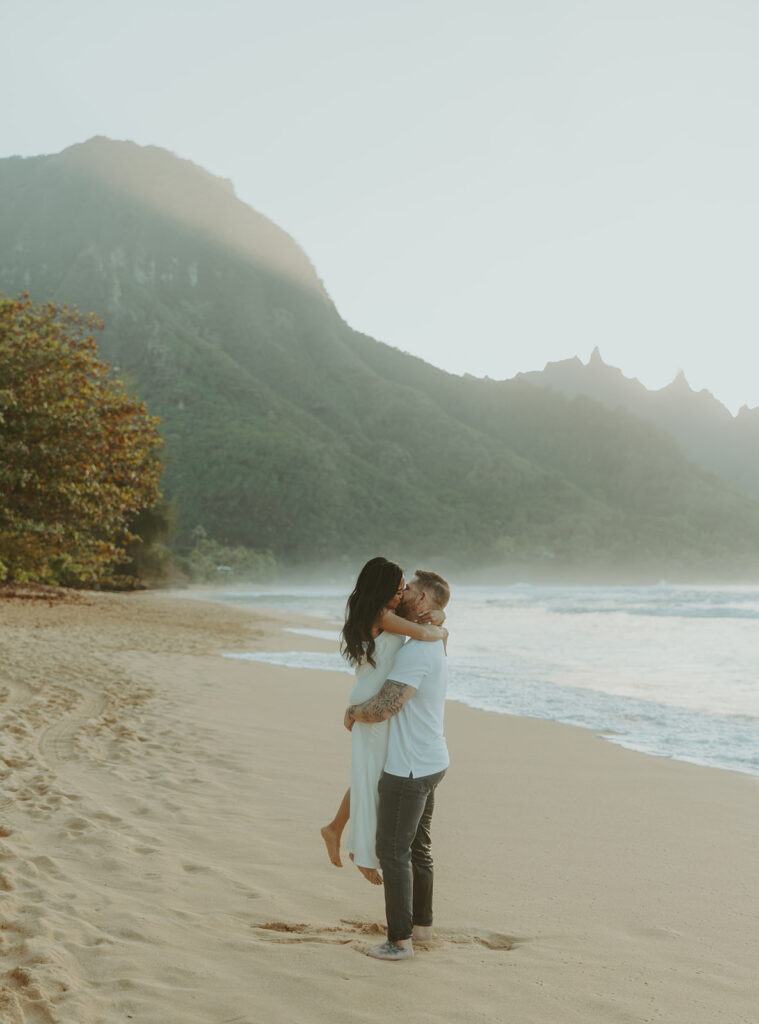 Engaged couple hugging and laughing during beach photoshoot
