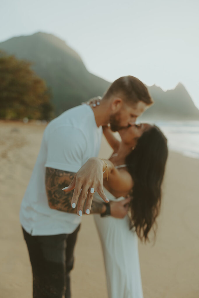 Couple standing together on Tunnels Beach at sunset