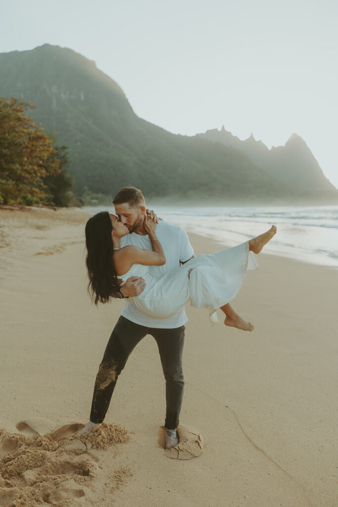 Engaged couple hugging and laughing during beach photoshoot
