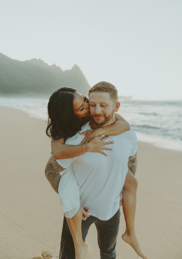 Engaged couple hugging and laughing during beach photoshoot
