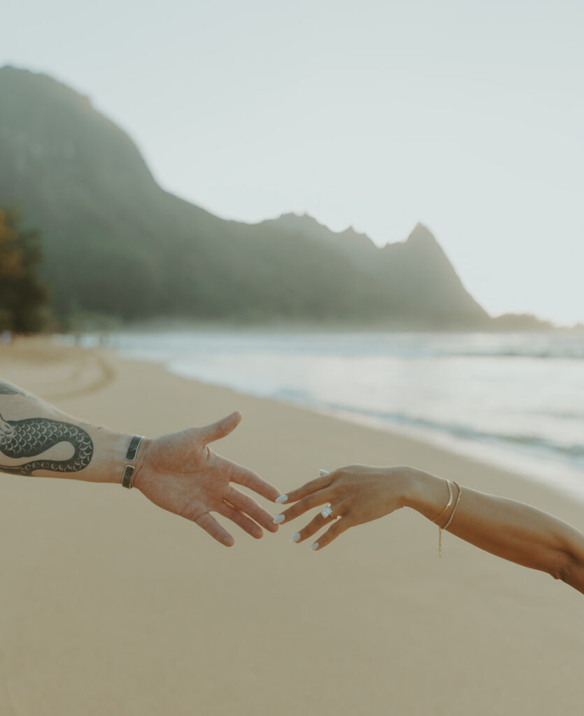 Engaged couple hugging and laughing during beach photoshoot
