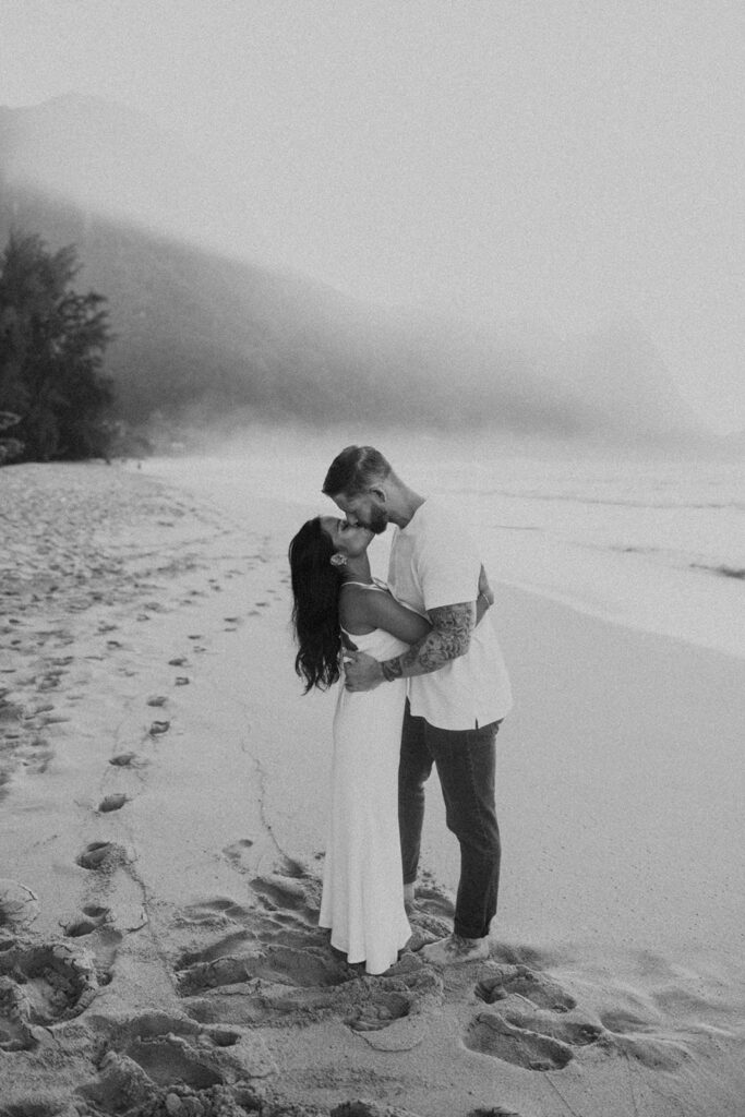 Candid moment of couple walking along the shoreline at Tunnels Beach
