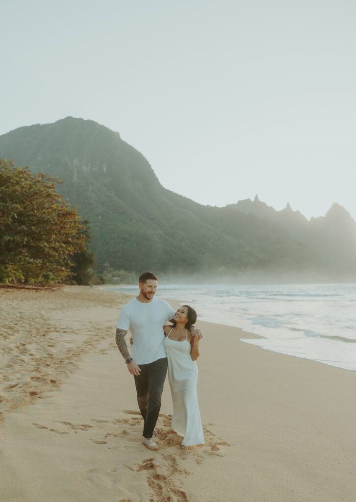 Engaged couple hugging and laughing during beach photoshoot
