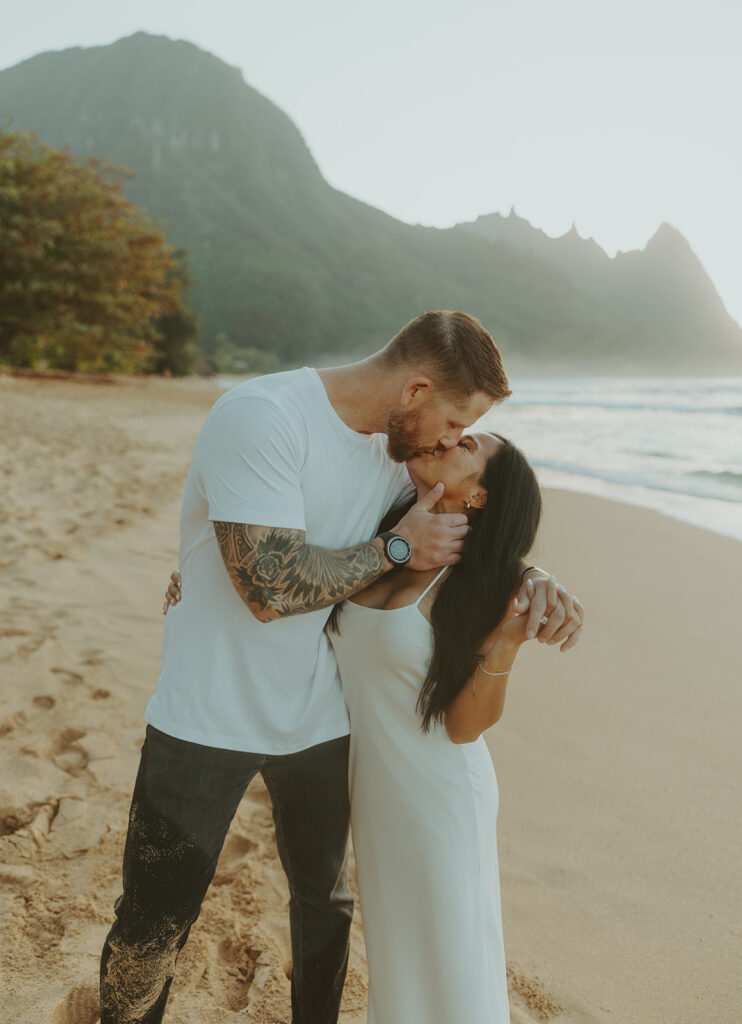 Engaged couple hugging and laughing during beach photoshoot
