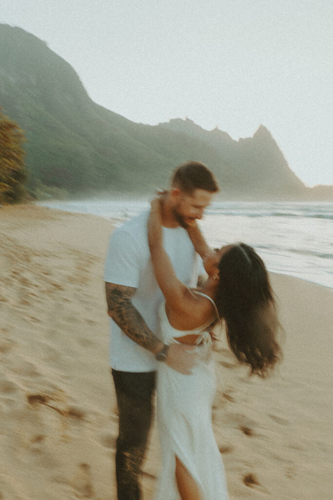 Candid moment of couple walking along the shoreline at Tunnels Beach
