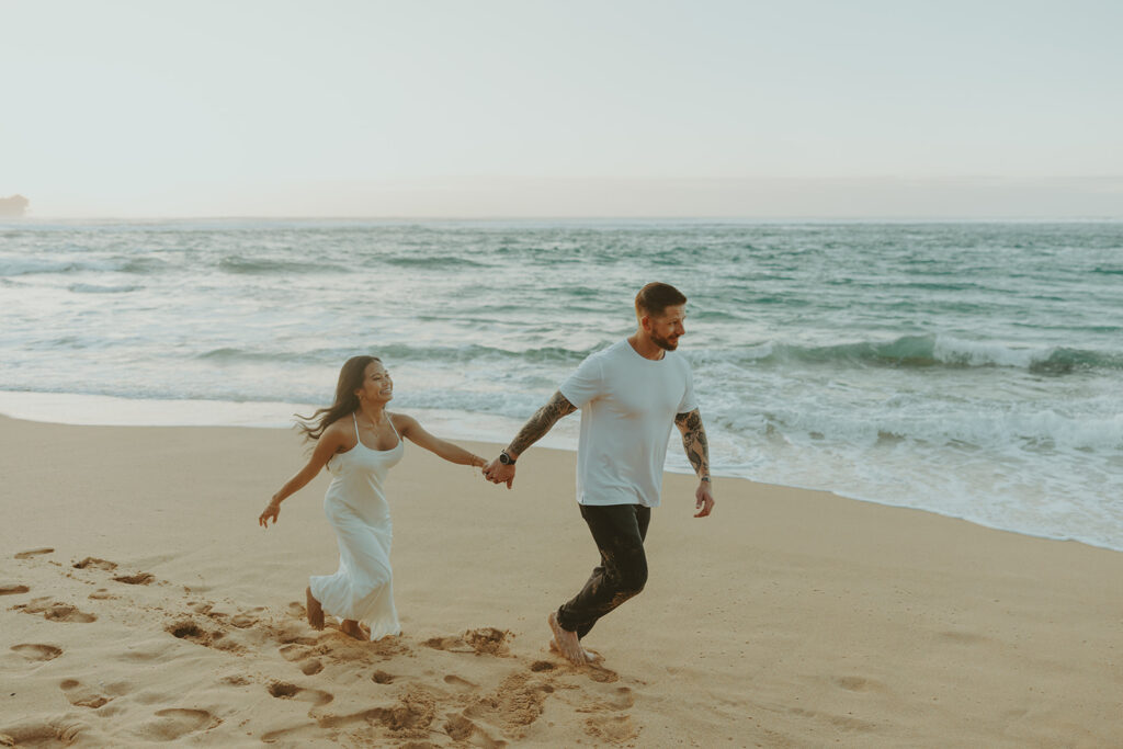 Candid moment of couple walking along the shoreline at Tunnels Beach

