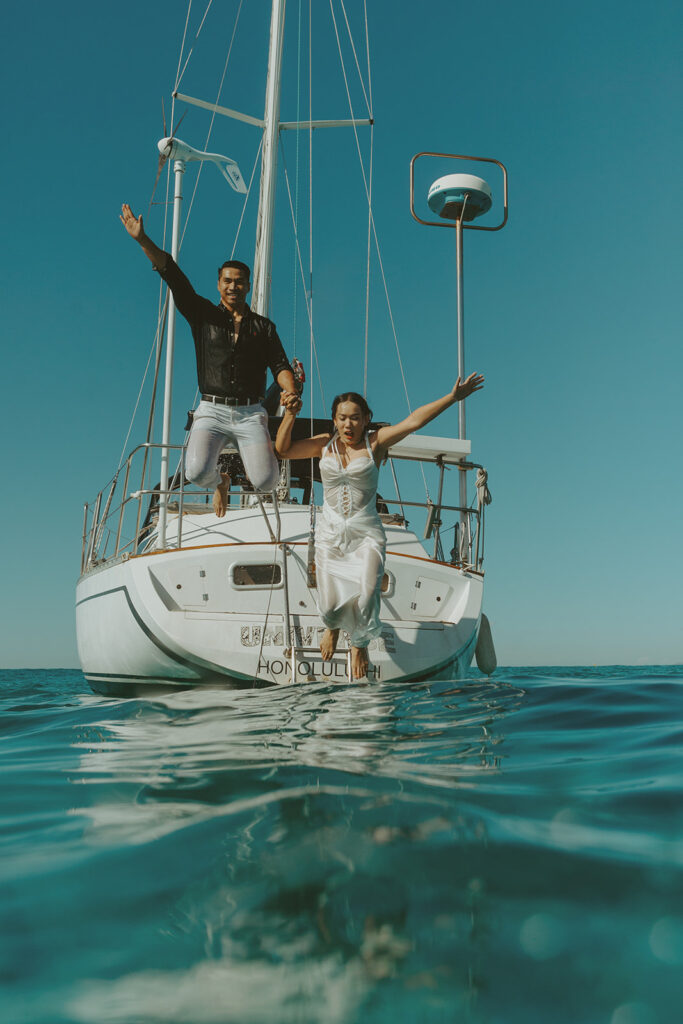Romantic couple embracing on a sailboat during a Waikiki sailboat photoshoot in Oahu, Hawaii
