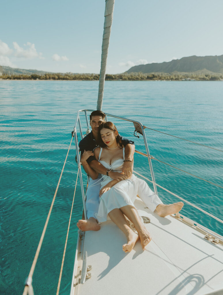 Romantic couple embracing on a sailboat during a Waikiki session in Oahu, Hawaii
