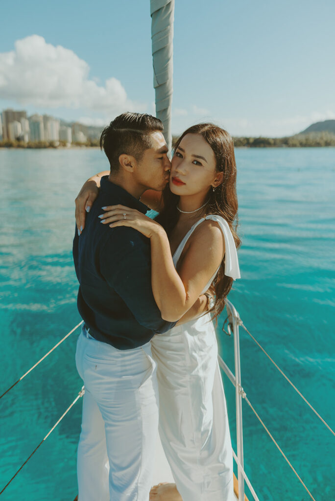 Intimate moment between couple captured during a dreamy sailboat engagement session
