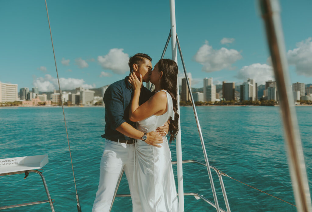 Romantic couple embracing on a sailboat during a Waikiki session in Oahu, Hawaii
