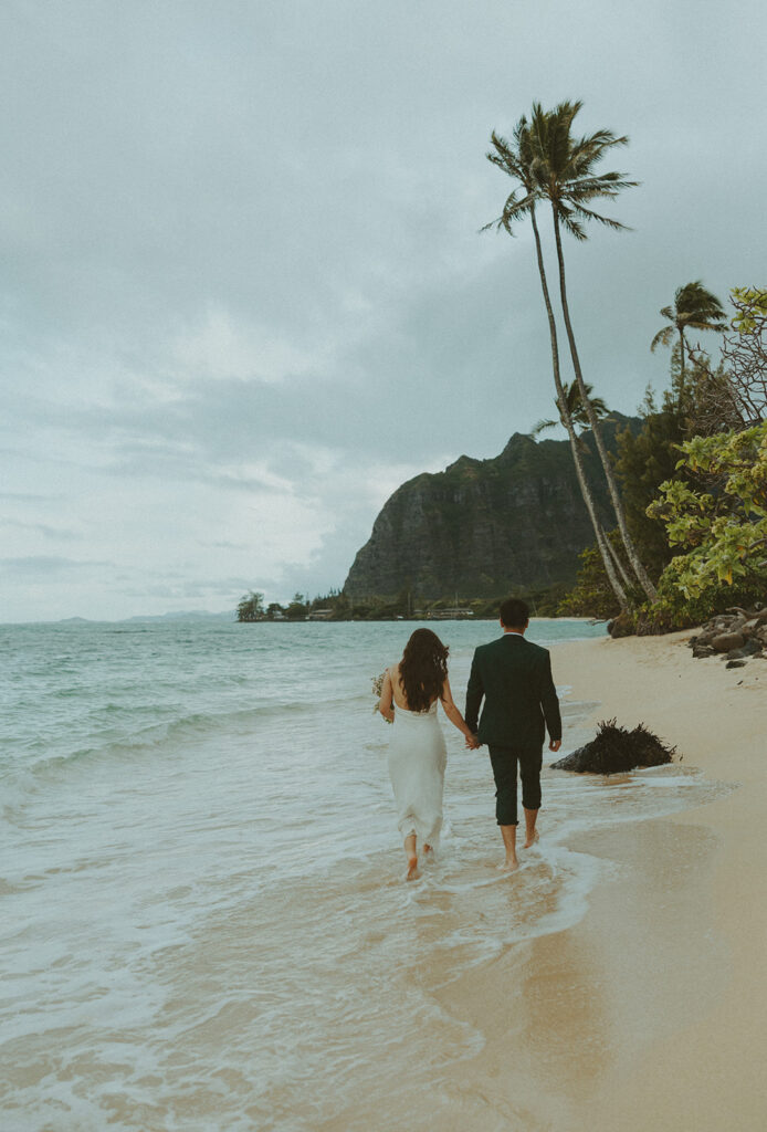 Couple standing together at the top of Crouching Lion hike with ocean views in the background