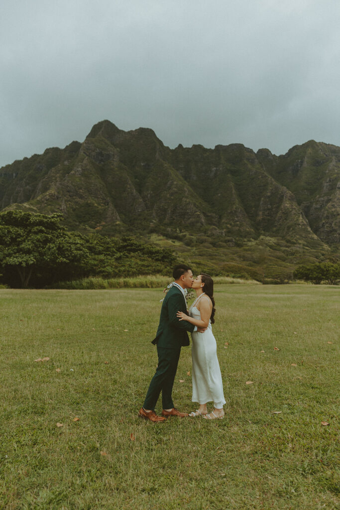 Couple holding hands while hiking through lush greenery on Oahu trail
