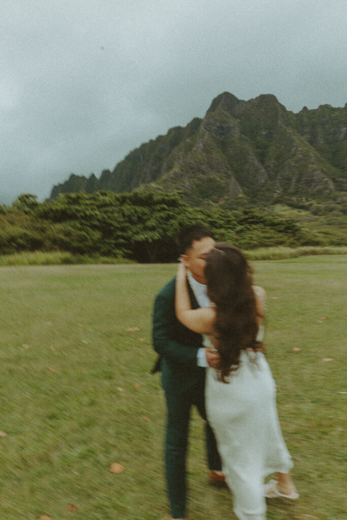 Couple holding hands while hiking through lush greenery on Oahu trail
