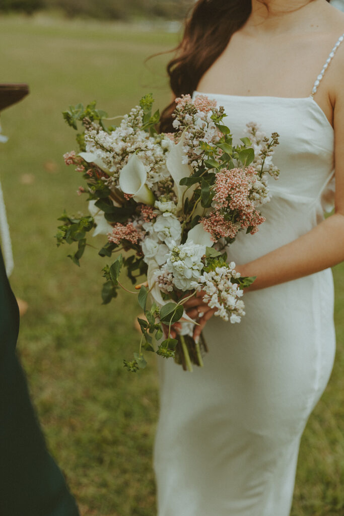 Elopement ceremony at Kualoa Regional Park with tropical floral details
