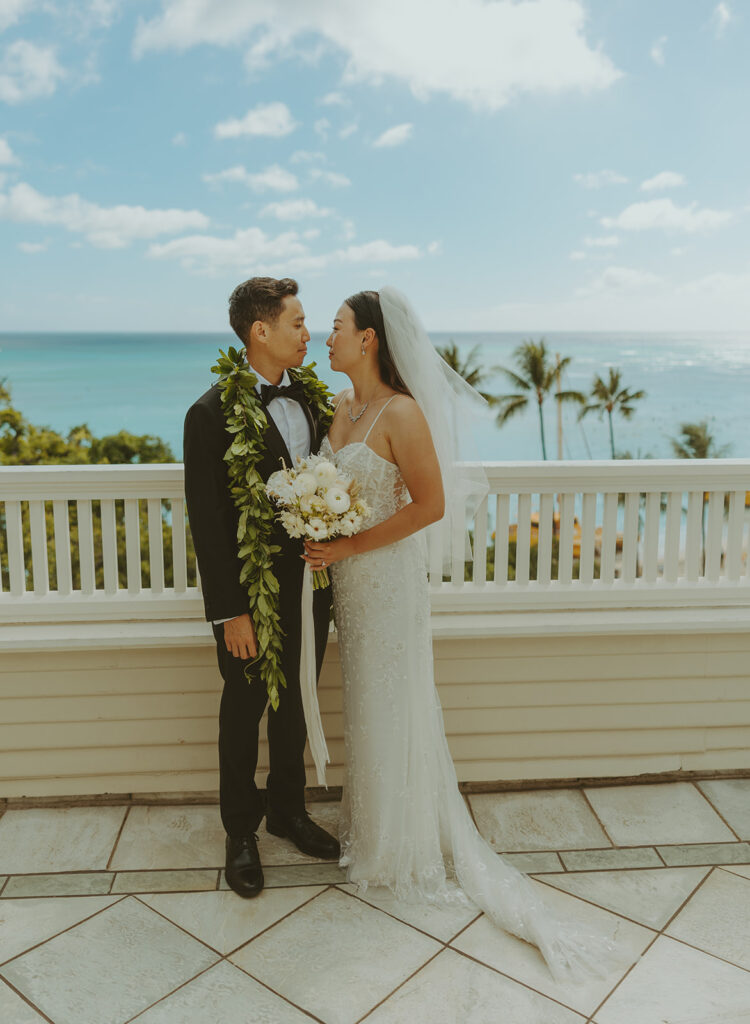 Groom and the bride on a terrace with ocean views at Moana Surfrider
