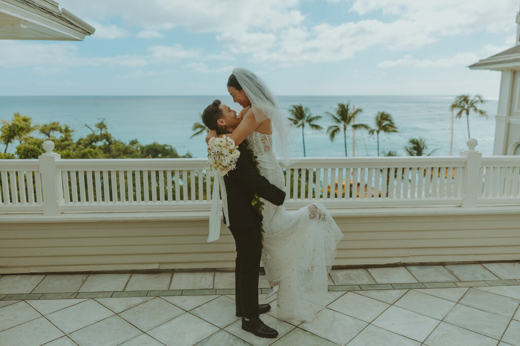 Groom and the bride on a terrace with ocean views at Moana Surfrider
