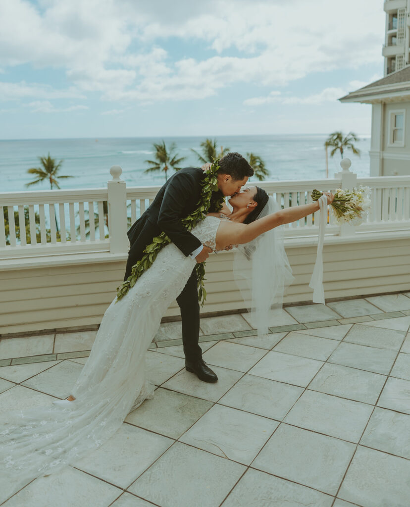 Groom and the bride on a terrace with ocean views at Moana Surfrider
